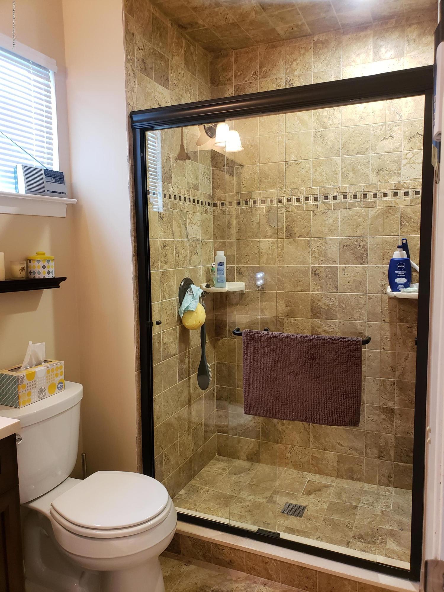 33 Mill Road, Unit 64 Whiting, NJ 08759 - Photo 6 of 23 a bathroom with a granite countertop toilet a sink and shower