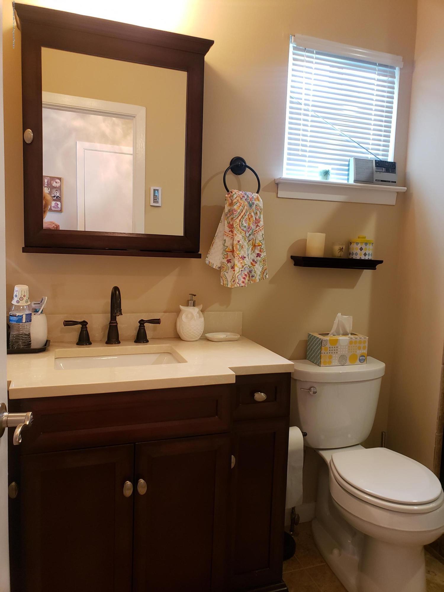 33 Mill Road, Unit 64 Whiting, NJ 08759 - Photo 8 of 23 a bathroom with a toilet sink and mirror