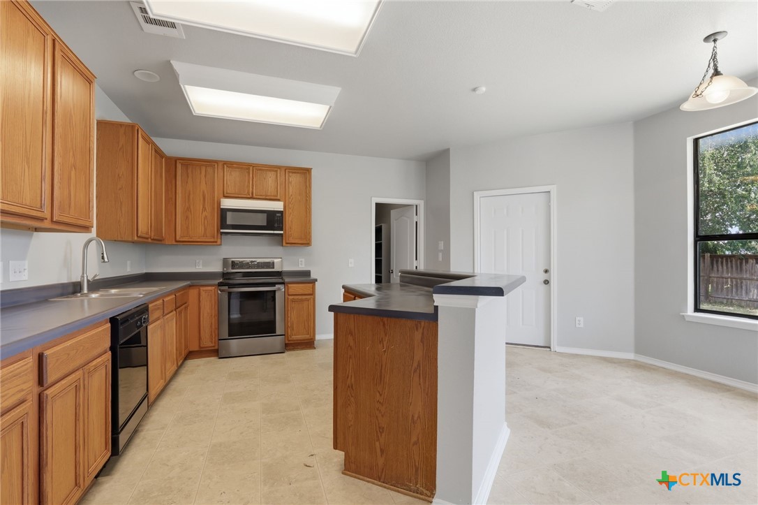 8716 Starview Street Temple, TX 76502 - Photo 7 of 36 Spacious kitchen setup with a center island, abundant wood cabinets, and ample counter space.