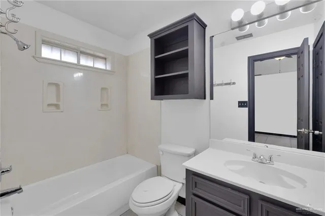 a bathroom with a sink a toilet a mirror and shower