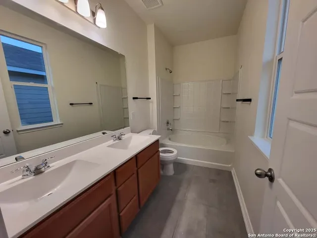 a bathroom with a tub sink toilet and a mirror