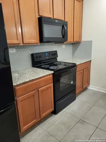 a kitchen with stainless steel appliances granite countertop a stove a sink and a microwave