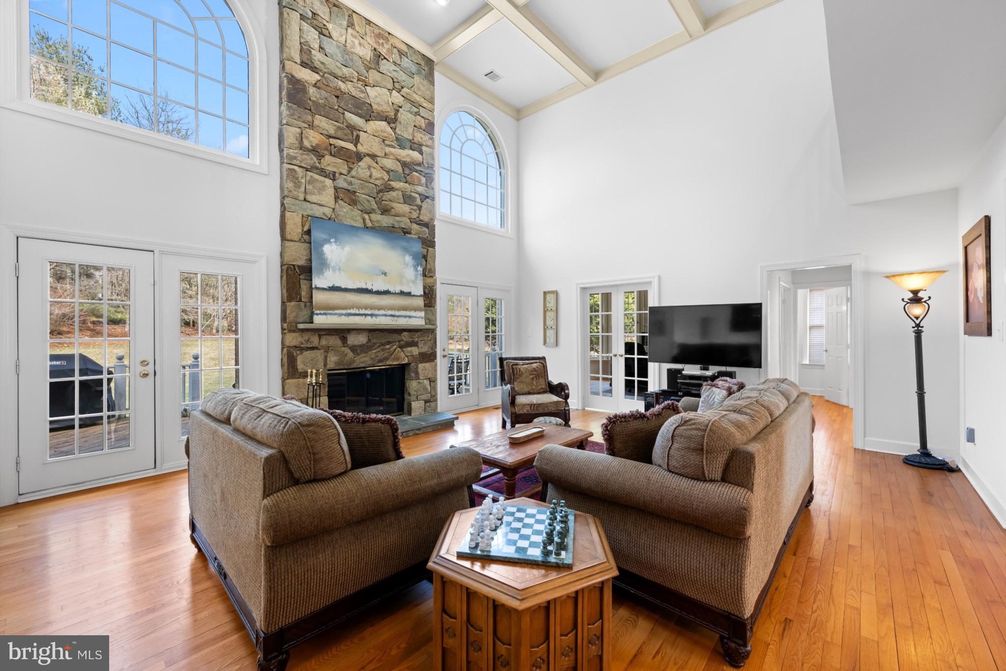9420 Crimson Leaf Terrace Potomac, MD 20854 - Photo 5 of 33 a living room with furniture a fireplace a flat screen tv and kitchen view