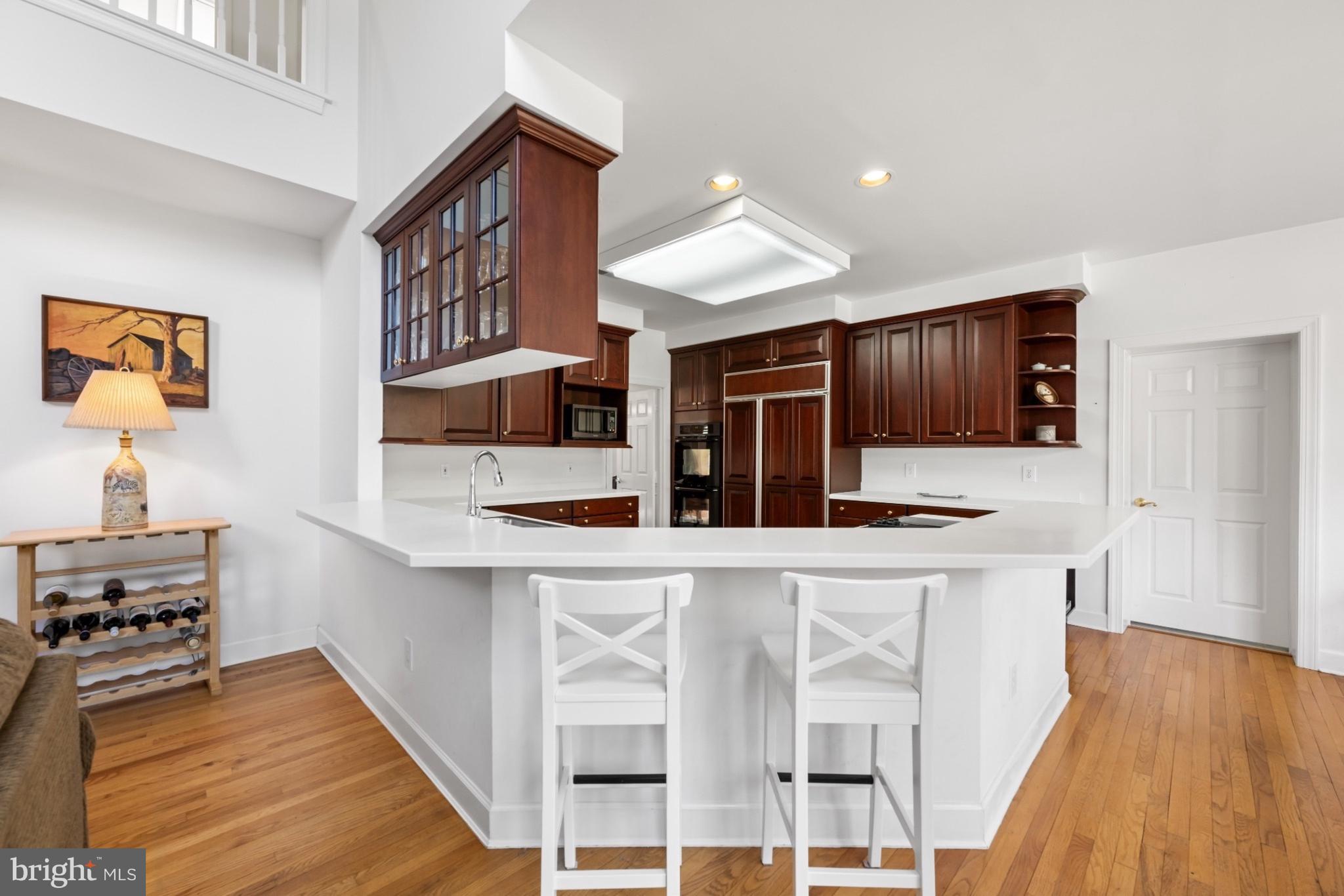 9420 Crimson Leaf Terrace Potomac, MD 20854 - Photo 9 of 33 a kitchen with stainless steel appliances kitchen island wooden floors and cabinets