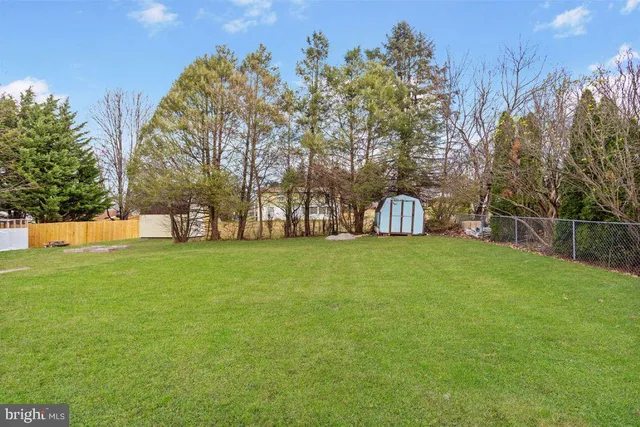 a green field with lots of trees in the background