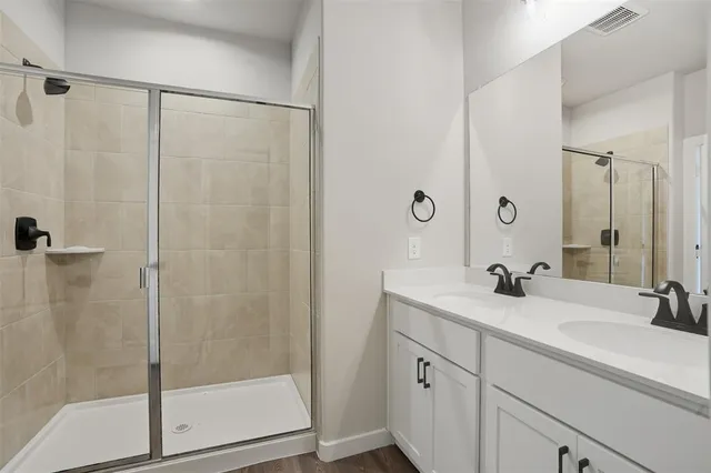a spacious bathroom with a double vanity sink a mirror and a toilet