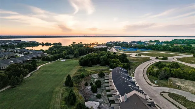 a view of a white house with large windows and plants