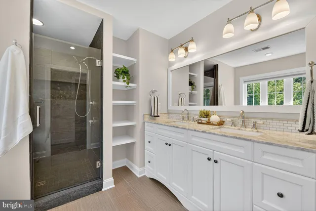 a view of a white house with a yard table and chairs under an umbrella