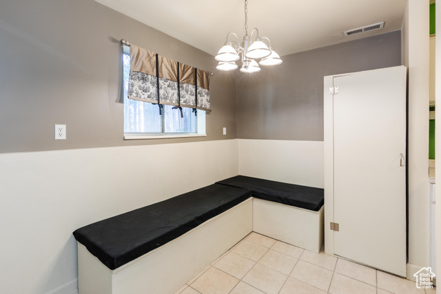 167 East 100 North, Unit B Logan, UT 84321 - Photo 8 of 18 Unfurnished dining area featuring light tile patterned floors and a chandelier