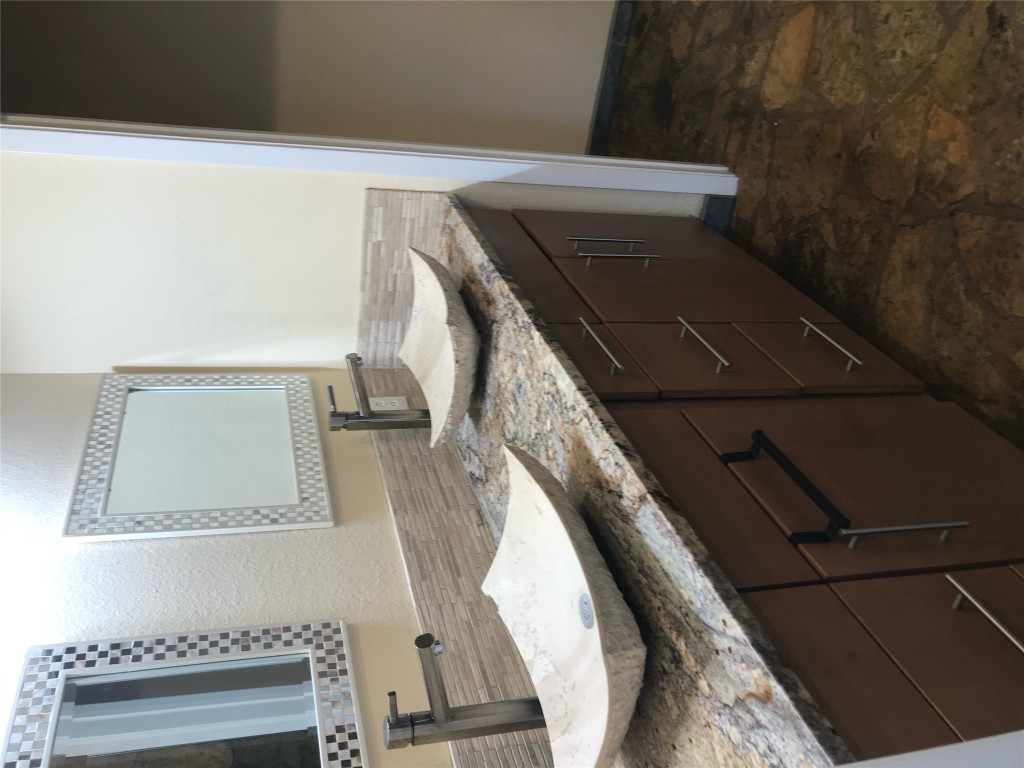 19600 Bee Creek Tavern Road, Unit B Spicewood, TX 78669 - Photo 12 of 13 a bathroom with a granite countertop sink and a mirror