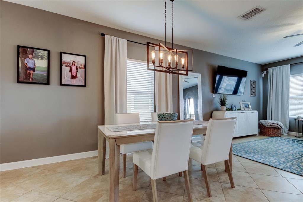 10141 Newminster Loop Ruskin, FL 33573 - Photo 16 of 77 a view of a dining room with furniture wooden floor and chandelier