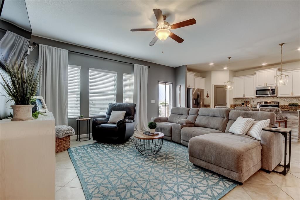 10141 Newminster Loop Ruskin, FL 33573 - Photo 17 of 77 a living room with furniture ceiling fan and a rug