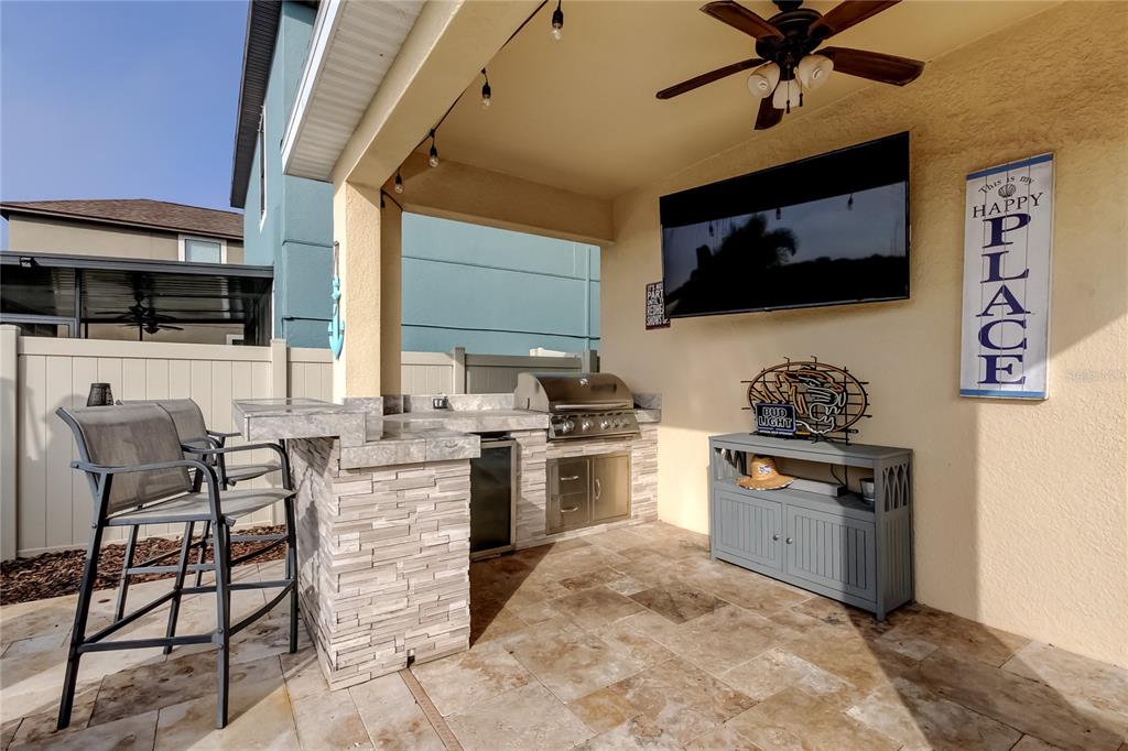 10141 Newminster Loop Ruskin, FL 33573 - Photo 59 of 77 a kitchen with stainless steel appliances granite countertop a stove top oven a sink a dining table and chairs with wooden floor