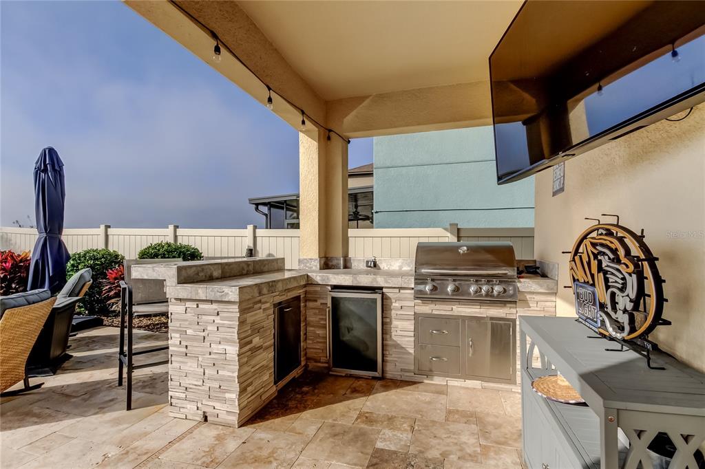 10141 Newminster Loop Ruskin, FL 33573 - Photo 60 of 77 a kitchen with a stove top oven cabinetry and a sink