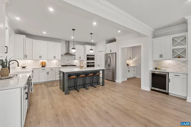 a kitchen with a stove a sink a center island and a window