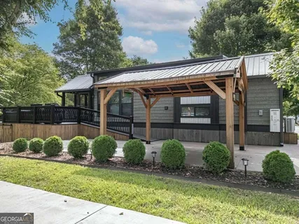 a view of backyard with swimming pool and seating space