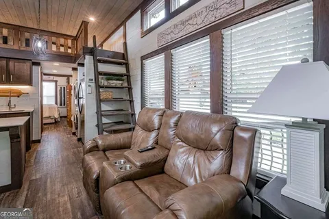 a living room with furniture a fireplace and wooden floor