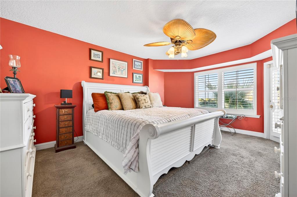 4670 Links Village Drive, Unit D506 Ponce Inlet, FL 32127 - Photo 19 of 60 a bedroom with a bed and a chandelier