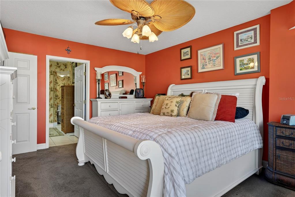 4670 Links Village Drive, Unit D506 Ponce Inlet, FL 32127 - Photo 20 of 60 a bedroom with a bed and a chandelier