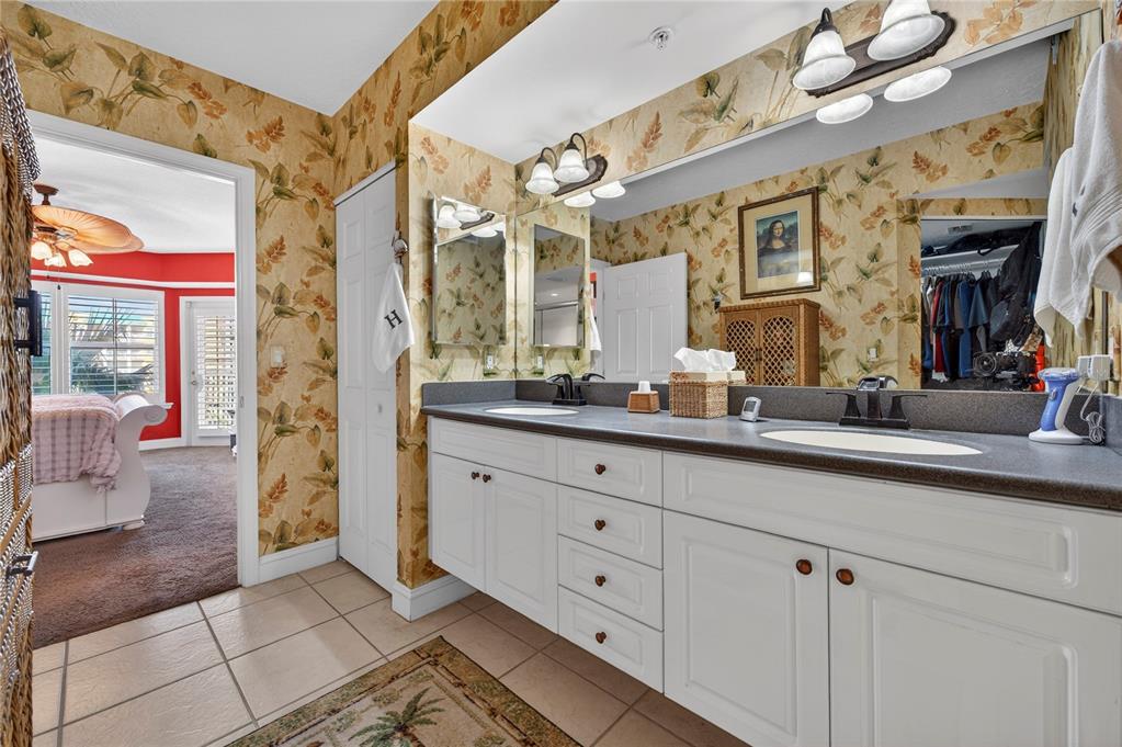 4670 Links Village Drive, Unit D506 Ponce Inlet, FL 32127 - Photo 22 of 60 a bathroom with a sink a large mirror and a shower