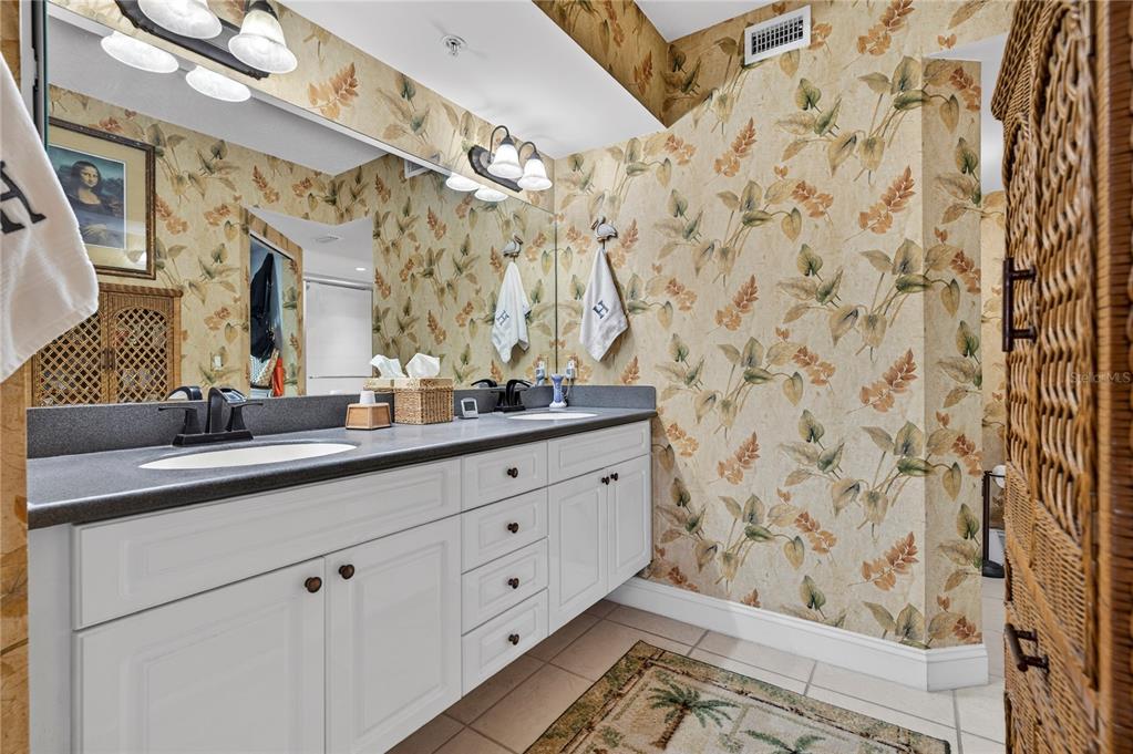 4670 Links Village Drive, Unit D506 Ponce Inlet, FL 32127 - Photo 23 of 60 a bathroom with a granite countertop sink a mirror and shower