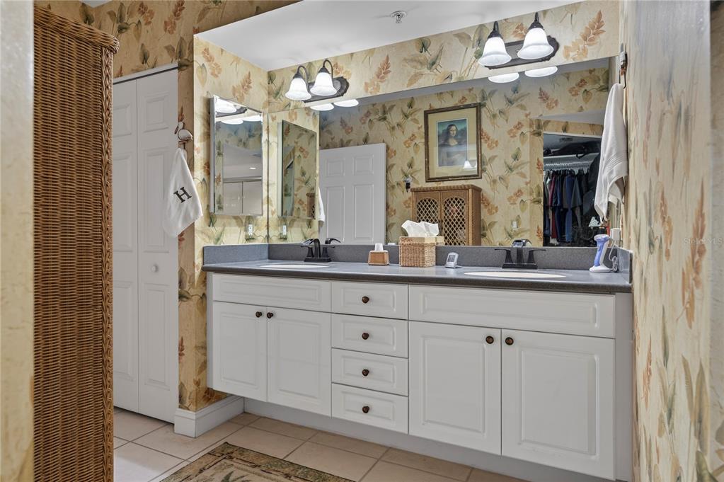 4670 Links Village Drive, Unit D506 Ponce Inlet, FL 32127 - Photo 24 of 60 a bathroom with a double vanity sink and a mirror