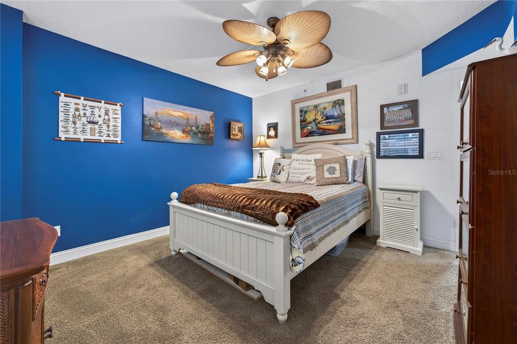 4670 Links Village Drive, Unit D506 Ponce Inlet, FL 32127 - Photo 28 of 60 a bedroom with a bed and a chandelier