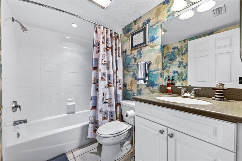 4670 Links Village Drive, Unit D506 Ponce Inlet, FL 32127 - Photo 30 of 60 a bathroom with a sink a toilet a mirror a bathtub and shower