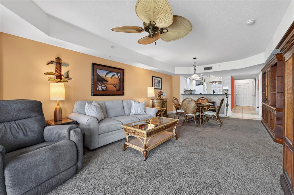 4670 Links Village Drive, Unit D506 Ponce Inlet, FL 32127 - Photo 6 of 60 a living room with furniture a chandelier fan and a rug