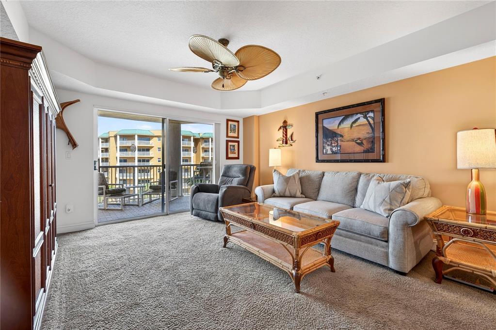 4670 Links Village Drive, Unit D506 Ponce Inlet, FL 32127 - Photo 7 of 60 a living room with furniture and a large window