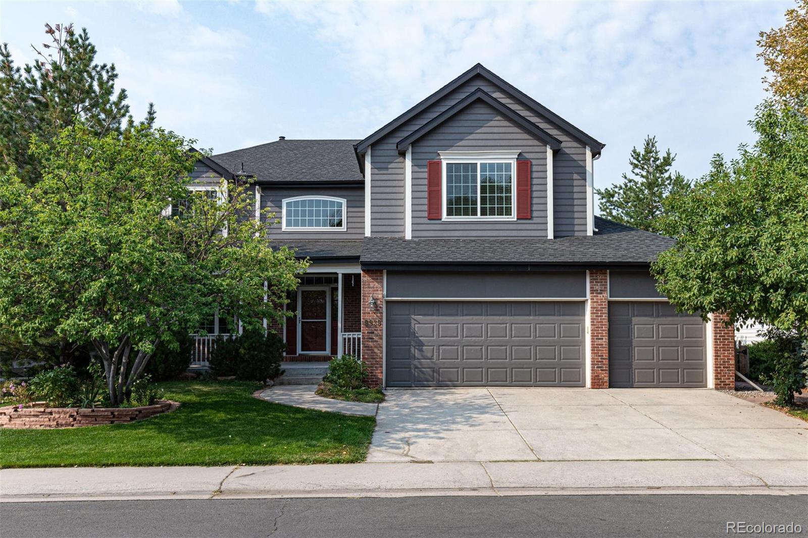 9939 Clyde Circle Highlands Ranch, CO 80129 - Photo 1 of 37 a front view of a house with a garden and garage