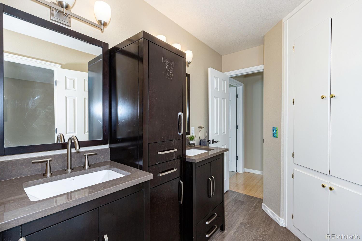 9939 Clyde Circle Highlands Ranch, CO 80129 - Photo 21 of 37 a bathroom with double vanity and a mirror