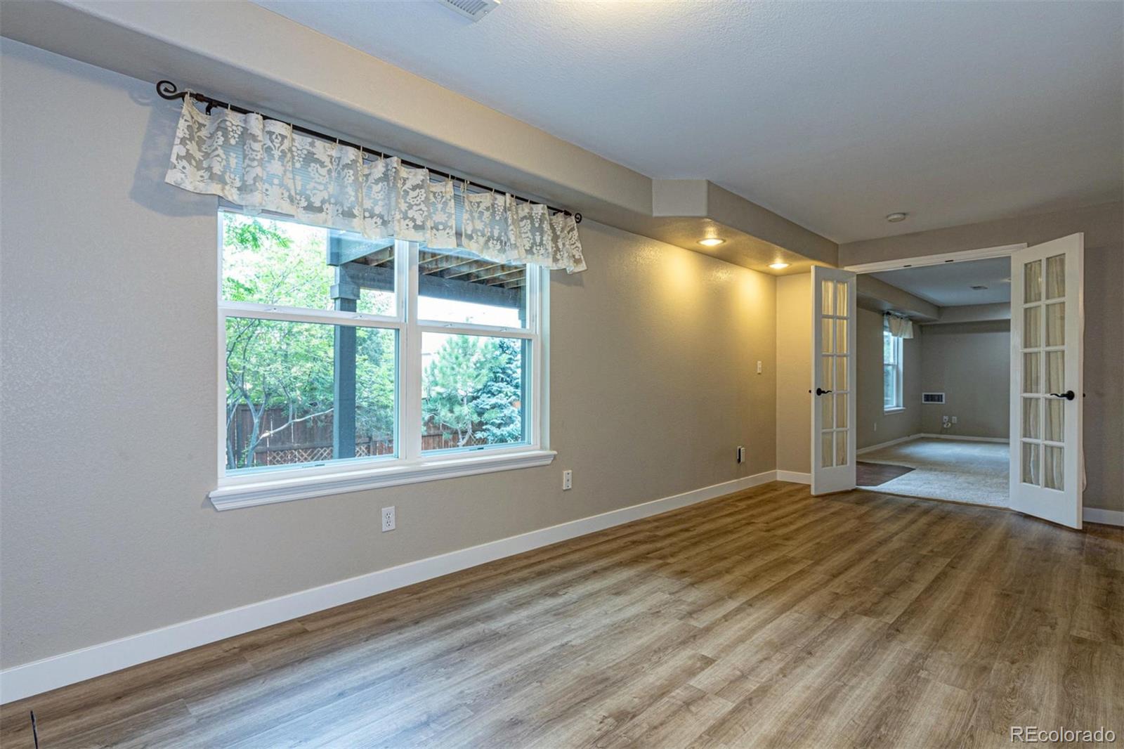 9939 Clyde Circle Highlands Ranch, CO 80129 - Photo 26 of 37 a view of an empty room with wooden floor and a window