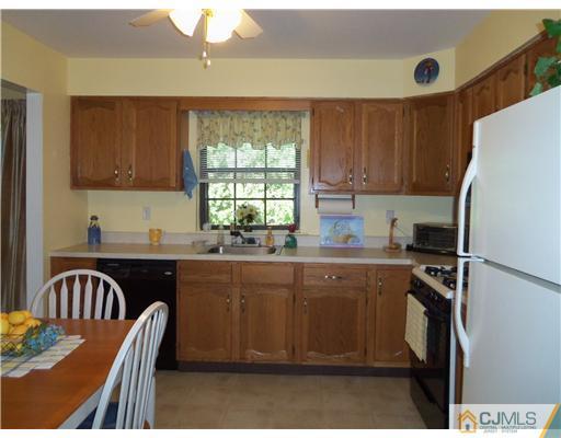 804 Maplecrest Road Edison, NJ 08820 - Photo 11 of 12 a kitchen with granite countertop a stove a sink dishwasher and a refrigerator with wooden floor