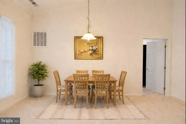 a dining room with furniture and potted plants