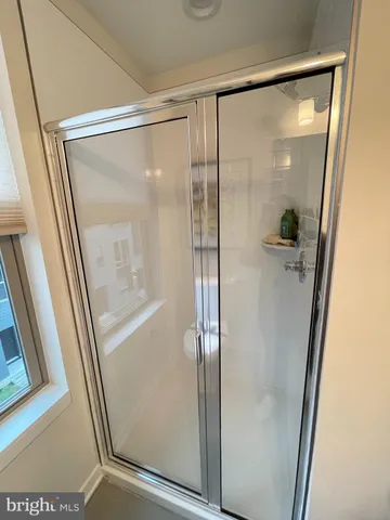 a bathroom with a glass shower door and mirror