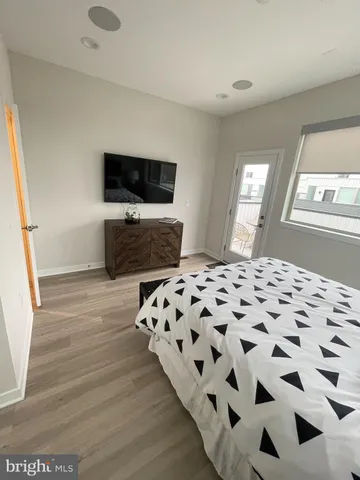 a bedroom with a bed and a flat tv screen on a dresser