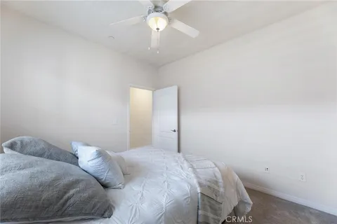 a bedroom with a bed and a ceiling fan