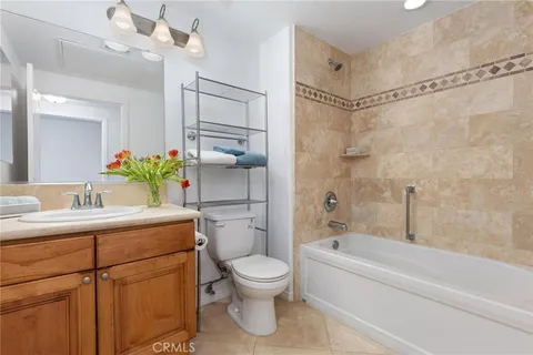 a bathroom with a granite countertop sink a toilet and shower