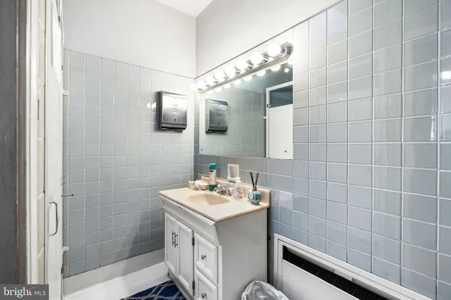 a bathroom with a sink mirror and shower