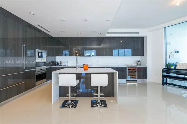 a kitchen with a table chairs refrigerator and cabinets