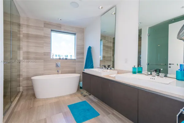 a bathroom with a bathtub sink and mirror