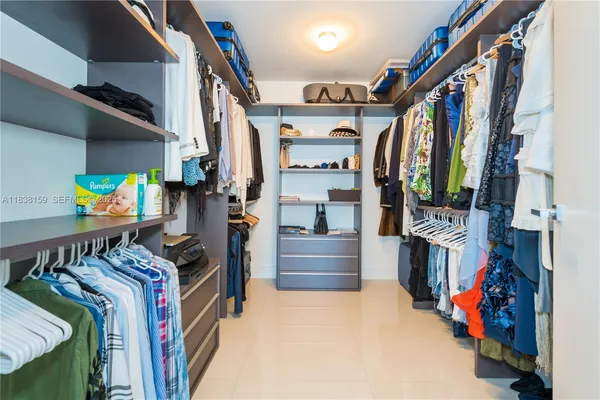 a view of walk in closet with clothes and shoes