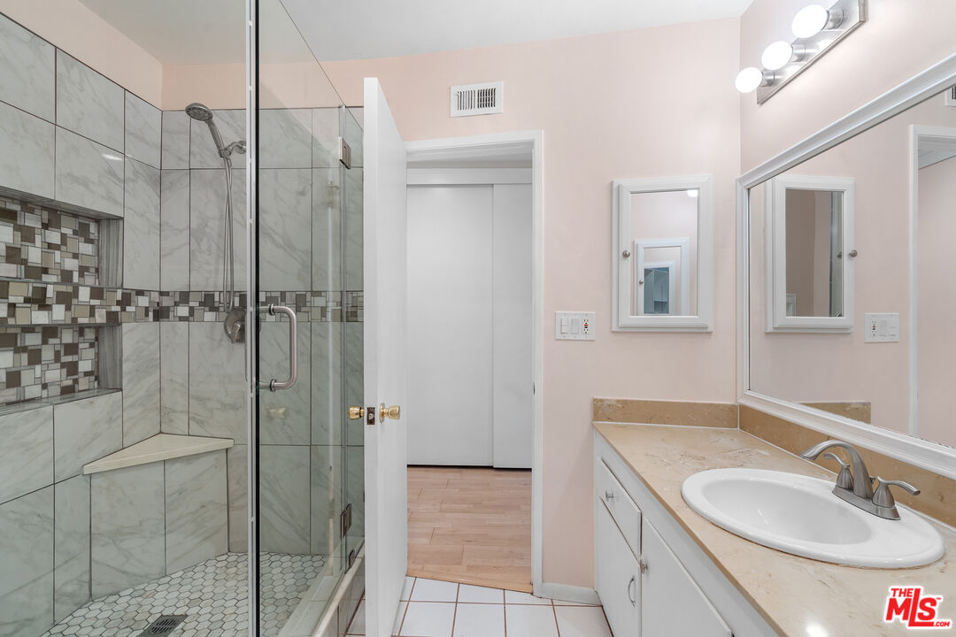 9631 Crystal View Drive Tujunga, CA 91042 - Photo 34 of 37 a bathroom with a granite countertop sink a shower and a mirror