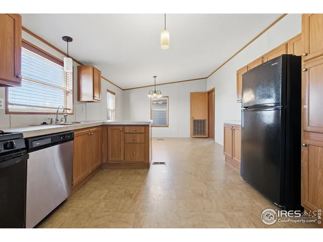 a kitchen with stainless steel appliances granite countertop a refrigerator a sink dishwasher and a stove