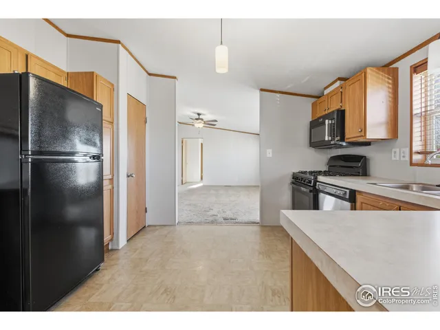 a kitchen with stainless steel appliances granite countertop a refrigerator a stove and a sink with granite countertops