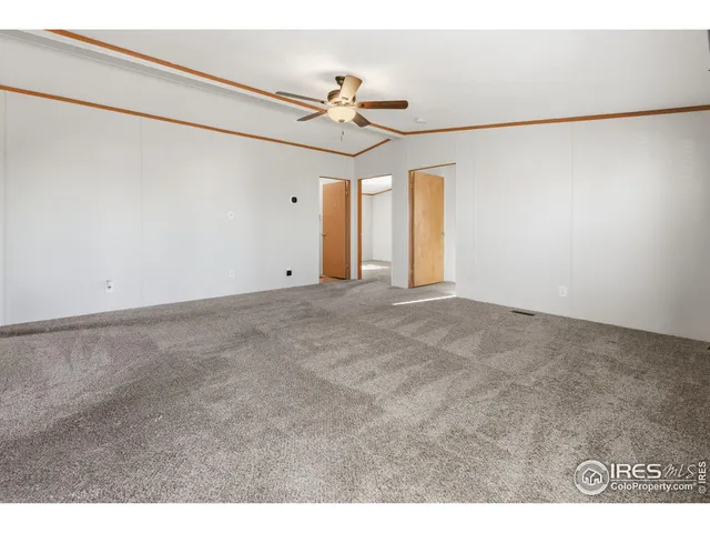 a view of an empty room with a ceiling fan and a window