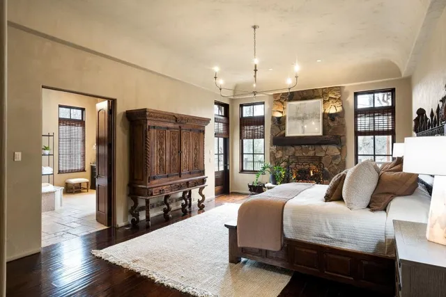 a view of a backyard with lawn chairs plants and trees