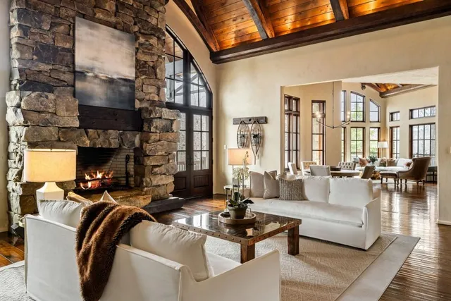 a living room with furniture fireplace and large windows