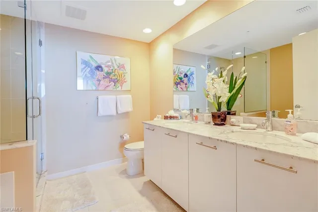 a bathroom with a granite countertop sink mirror vanity and toilet
